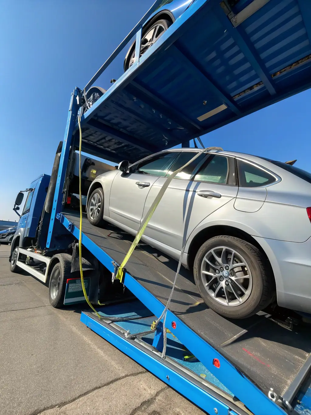 A high-quality image depicting a car being carefully loaded onto a transport truck at a dealership, showcasing the professionalism and care taken by Throttle & Shift Auto Transport.
